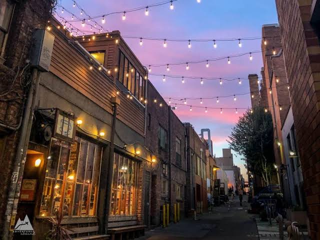 Coffeehouse alley illuminated by string lights at sunset