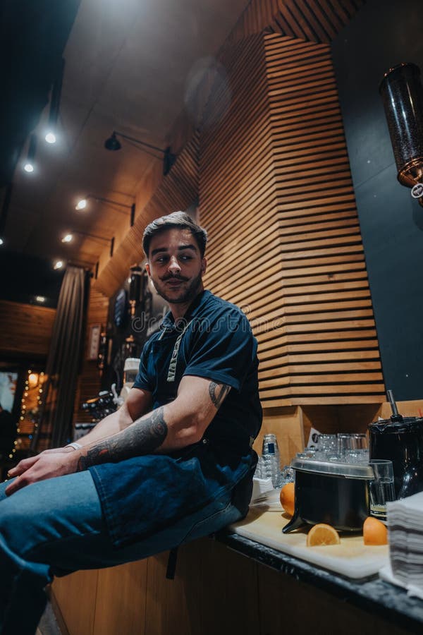 Barista seated beside a contemporary coffee bar