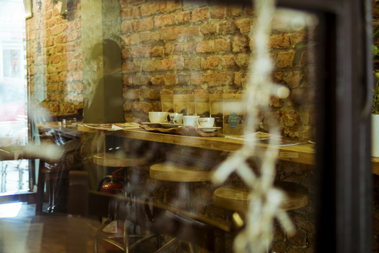 Warm vintage café interior with a brick wall, wooden counter, and coffee cups